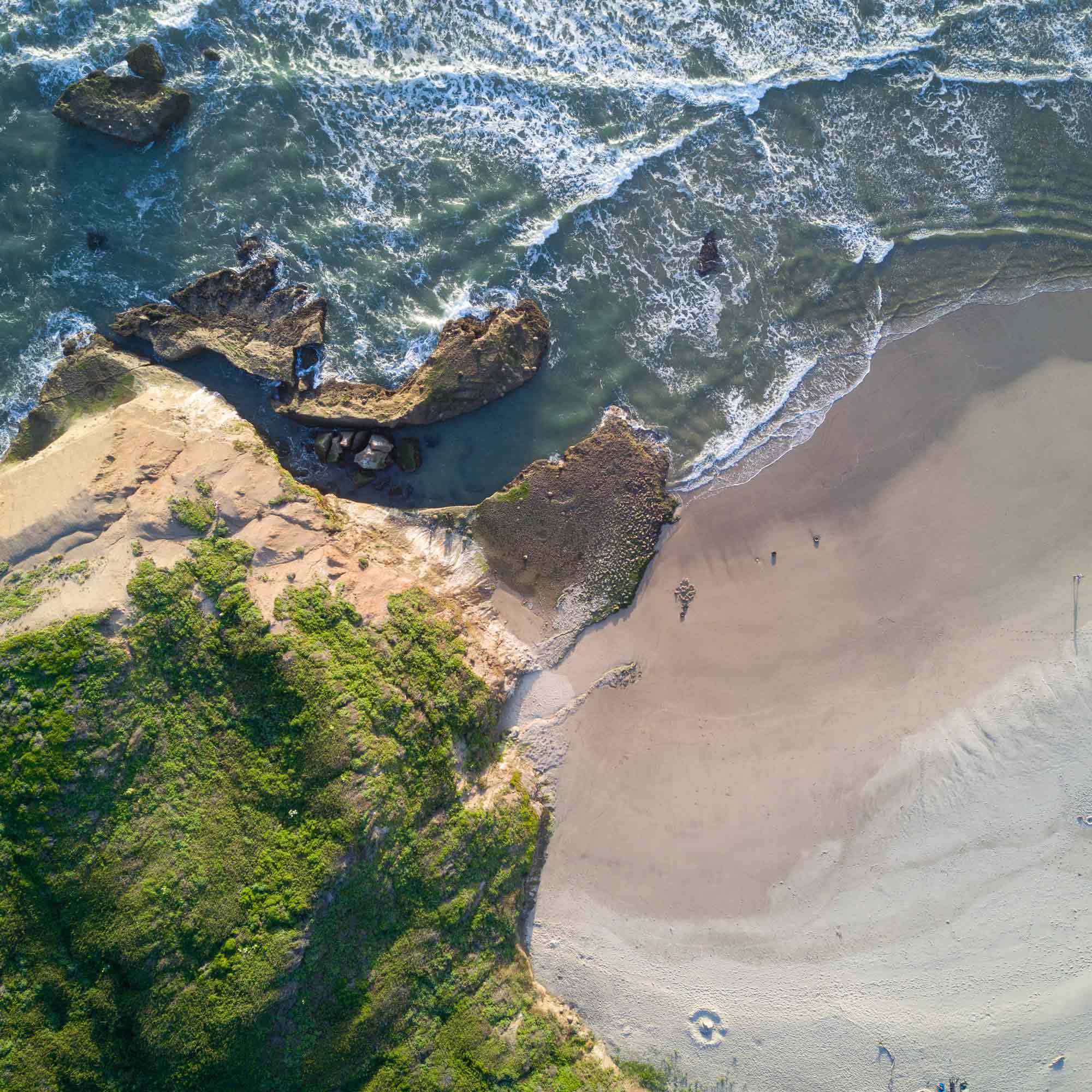 An aerial view of waves crashing against a shore.